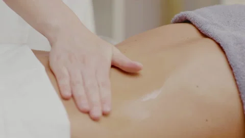 Masseur hands stroke client back in oil on massage table in spa room. Stock Footage 197675175