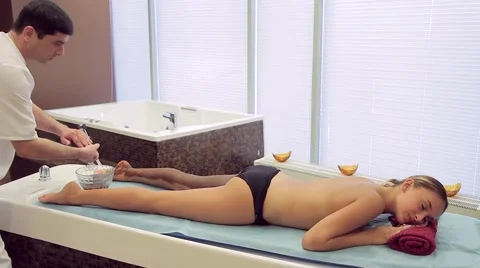 Masseur makes chocolate wrapping young woman Video stock 66760331