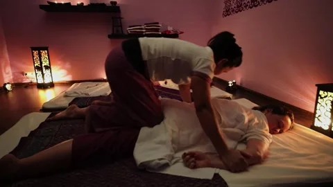 Masseur presses at hands of client which lies on mattress in spa center Video stock 276377806