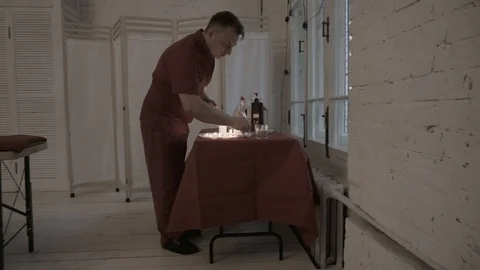 Masseur at table with candles Stock Footage 92127388