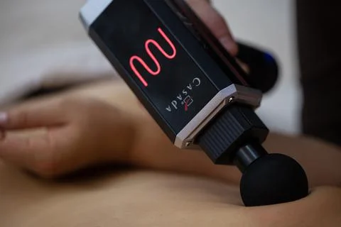 Masseur using Electric massager Machine  Casada MediGun Stock Photos