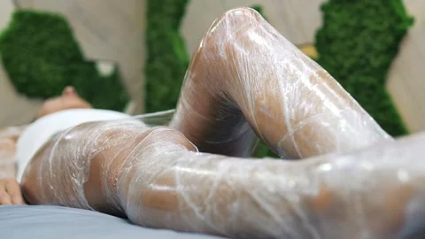 A masseuse in black gloves does an ANTI-CELLULITE MASSAGE OR A WEIGHT LOSS WRAP Stock Footage 156286292