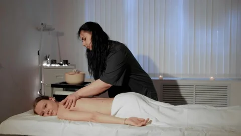 A masseuse makes a back massage to a young woman in a spa center, close-up. Stock Footage 236981358