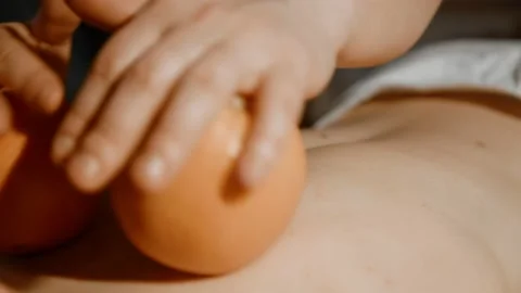 Masseuse makes a massage with an orange to a young woman Stock Footage 236982279
