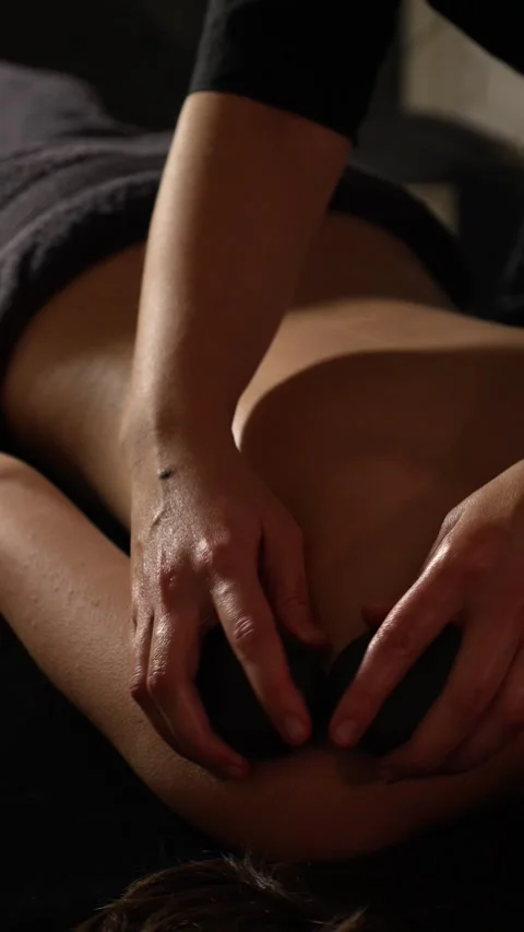 Masseuse massages back with a stone. stone massage. stone therapy. Stock Footage 318247384