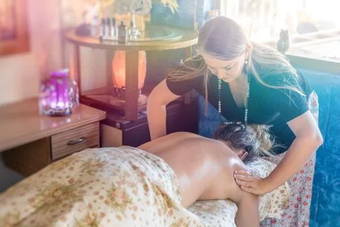 Masseuse massaging her client back. Stock Photos