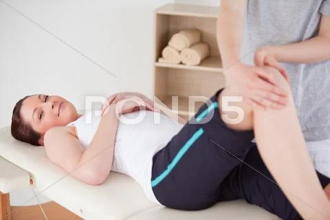 Masseuse massing the knee of a beautiful woman Stock Photos