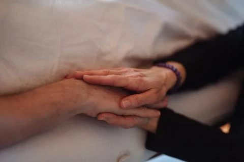 A masseuse touching the hands of a client. Stock Photos