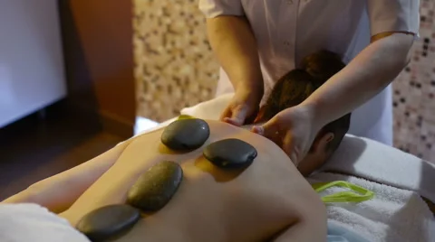 Masseuse using hot stone massage therapy 库存影片 62634711