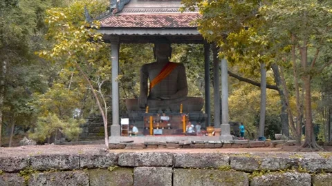 Massive ancient Buddha statue sits still in a pavilion with an altar Video stock 318657113