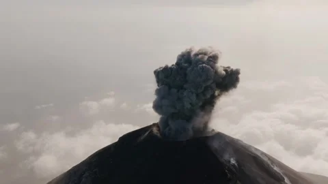 Massive ash column rises vertically from Fuego Volcano above cloud layer in Stock Footage 331053062