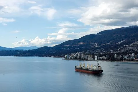 A massive cargo ship navigates under Lions Gate Bridge in Burrard Inlet, wi.. Stock Photos