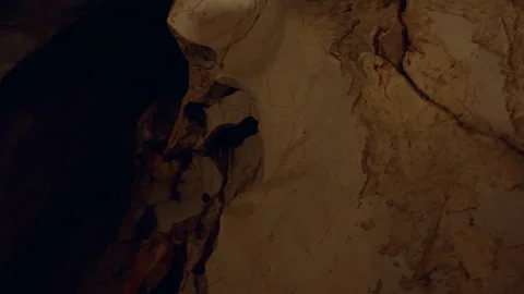 Massive Cave Ceiling With Layered Rock Formations Lit By Warm Light Creating Nat Stock Footage 323471172