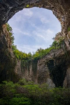 Massive cave ceiling opening to sky looking up Bulgaria karst Stock Photos
