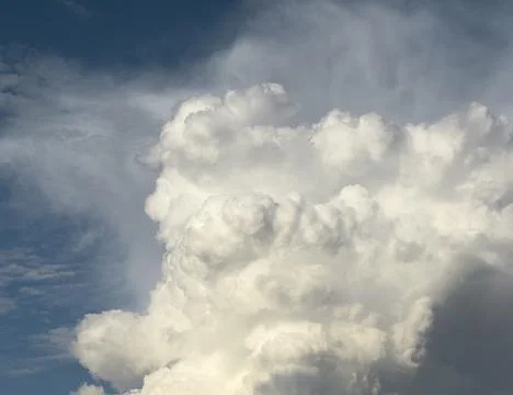 Massive cloud column rises against deep blue sky. Voluminous cumulus formatio 스톡 사진