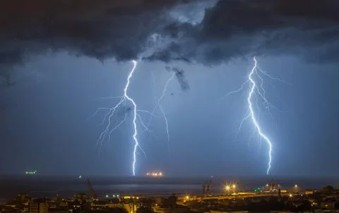 Massive cloud to ground lightning bolts hitting Stock Photos