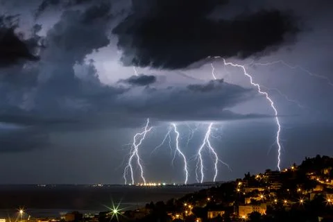 Massive cloud to ground lightning bolts hitting Stock Photos