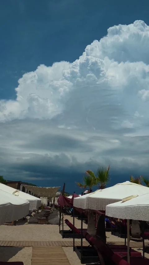 Massive cloud looms over beach umbrellas. Trani Ammouda, Vertical Stock Footage 340650937