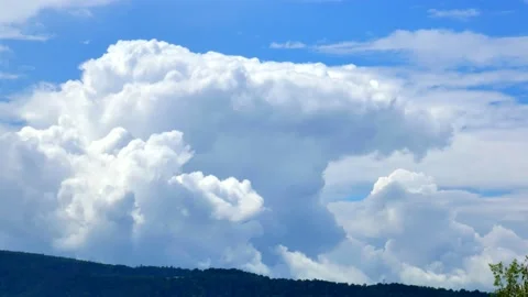 Massive clouds, cumulus congestus and cumulonimbus, above the top of the hill Stock Footage 156797091