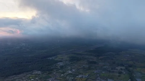Massive clouds loom low over a quiet valley Stock Footage 345501120