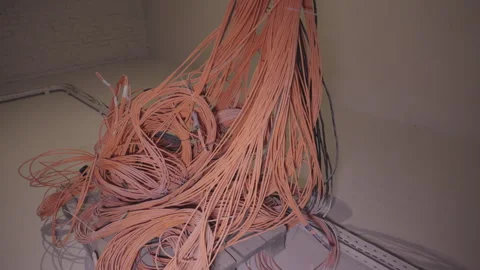 Massive cluster of orange flexible cables hangs from ceiling Stock Footage 328002585