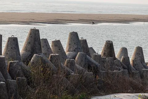 Massive concrete wave breakers standing guard against powerful tides along C Stock Photos