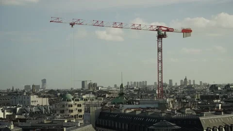 Massive construction crane working above Paris rooftops in the city Slow Stock Footage 170923632