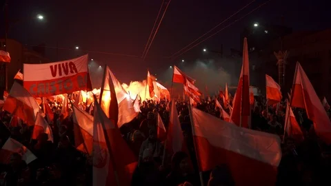 Massive crowd marching at night with flags and bright red flares during Stock Footage 98305248