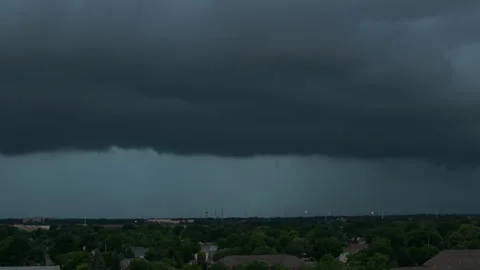Massive dark storm clouds approaching a residential area, showing dramatic Stockbeeldmateriaal 346790261