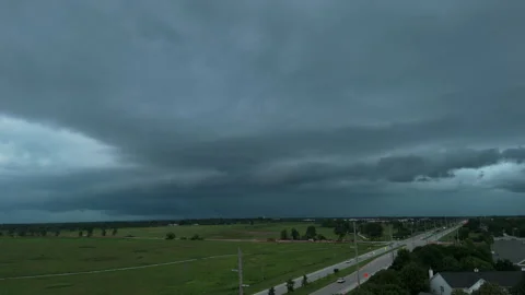 Massive dark storm clouds approaching a residential area, showing dramatic Stockbeeldmateriaal 346790370