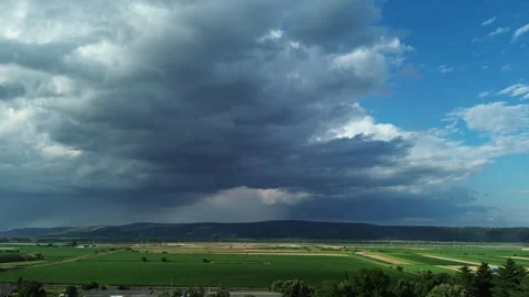 Massive Dark Storm Clouds Over Green Farmland – Dramatic Aerial Drone Landscape Stock Footage 341478966