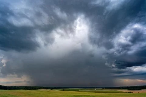 Massive dark storm clouds producing heavy rainfall Stock Photos