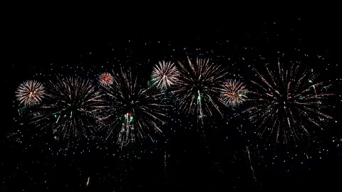 A massive firework bursts in the dark sky, creating a spectacular display of Stock Footage 273327529