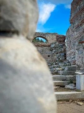 Massive Foreground Stone Frames Arched Passage and Steps in Sunlit Ruins Stock-Fotos