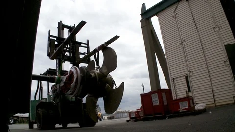 Massive forklift moves ship propellers around harbor and construction site Stock Footage 123724485