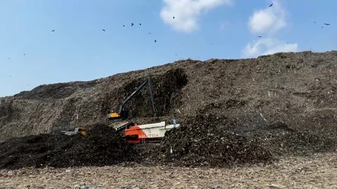 Massive garbage dump. Huge mountain of trash with birds flying in the background Stock Footage 336067545