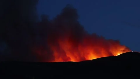 Massive glowing smoke cloud and flames from wildfire after sunset Poeville f Stock Footage 134777814