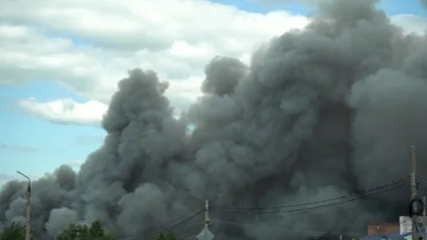 Massive Gray Smoke Plume Spreading Across the Sky During a Fire 스톡 동영상 343894635