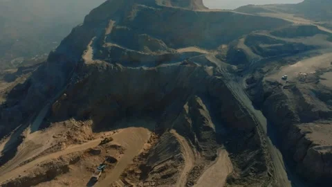 A massive heavy-duty mining truck engaged in large-scale excavation of natural 스톡 동영상 333681501