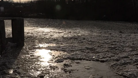Massive ice jam breaks in spring thaw causing flooding down river towards town Stock Footage 102427231