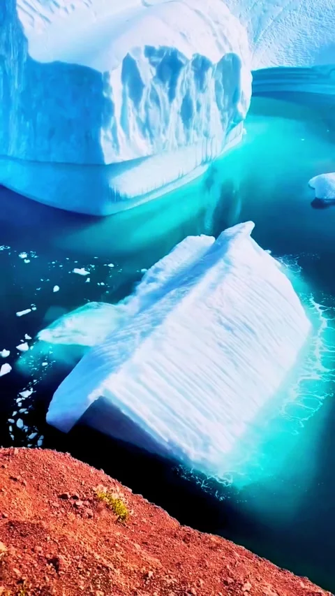 Massive iceberg dramatically rolls over in bright turquoise arctic water re.. Stock Footage 331482258
