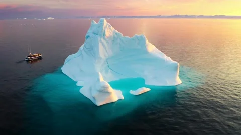Massive iceberg floating in ocean at golden sunset Stock Footage 340963378