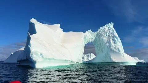 Massive iceberg with natural arch formation floating in the cold Arctic ocean. Stock Footage 341960706
