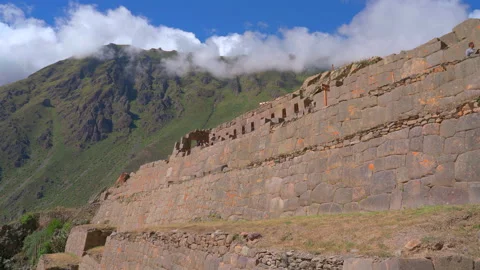Massive Inca stone wall and terraces with Andes mountains background in Stock Footage 345395236