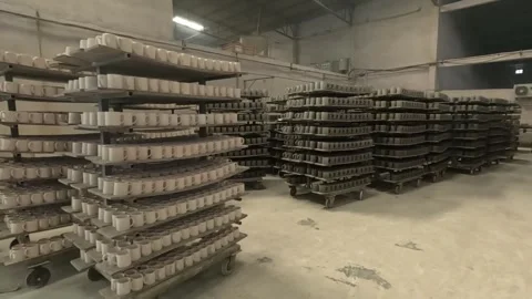 A massive inventory of raw ceramic mugs stacked systematically on industrial Stock Footage 325948798