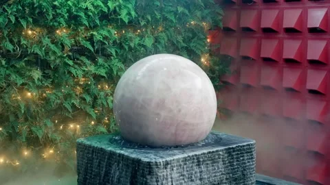 A massive jade or marble stone rotating sphere stands in the steam fountain Stock-Footage 333403496