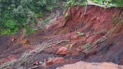 A massive landslide or mudslide cascades down a steep, red-earthed hillside.. 스톡 동영상 341353729