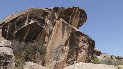 Massive limestone boulder formations on grassy hill in Gobustan  Stock Footage 340007325