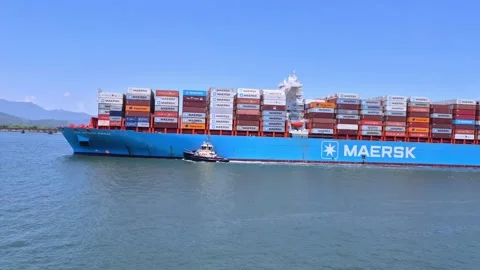 Massive Maersk container ship being guided by a tugboat in calm blue waters.. Stock Footage 345938968