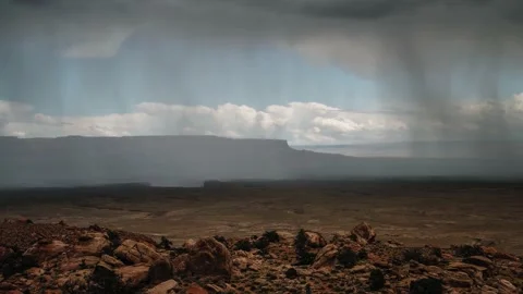 Massive monsoon cloud and storm dropping rain onto mountains and desert Stock Footage